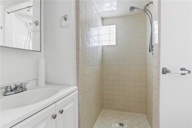 bathroom featuring a tile shower and vanity