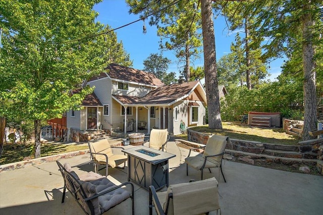 view of patio / terrace featuring a hot tub and a fire pit