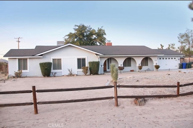 ranch-style house featuring fence, an attached garage, and stucco siding