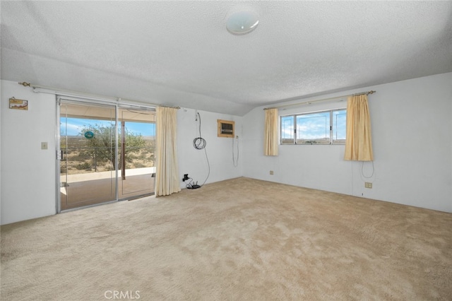 carpeted spare room featuring a textured ceiling and a wall unit AC