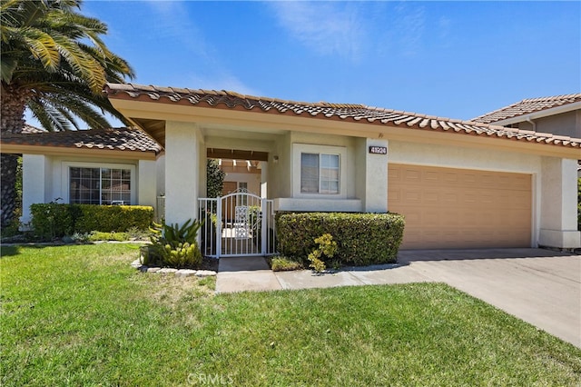 mediterranean / spanish house featuring a garage and a front lawn