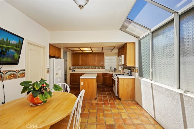 kitchen featuring decorative backsplash, white appliances, a center island, and sink