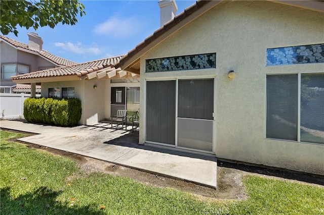 rear view of house featuring a patio and a yard