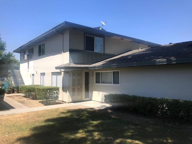 rear view of property featuring a lawn