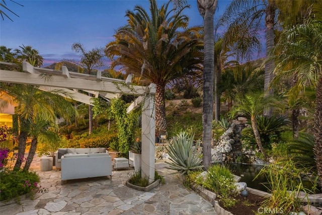 patio terrace at dusk featuring an outdoor living space and a pergola