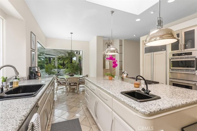 kitchen with light stone countertops, a kitchen island, and sink