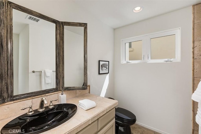 bathroom featuring vanity and toilet