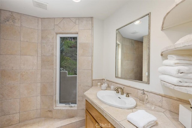 bathroom with vanity and tile walls