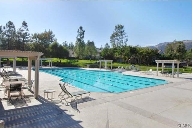 view of swimming pool with a pergola, a patio area, and a mountain view