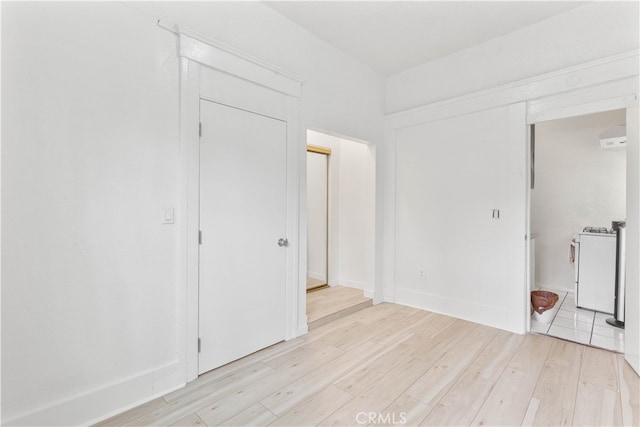 unfurnished bedroom featuring light hardwood / wood-style flooring and a closet