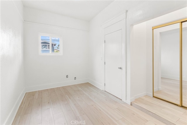 unfurnished bedroom featuring a closet and light hardwood / wood-style floors