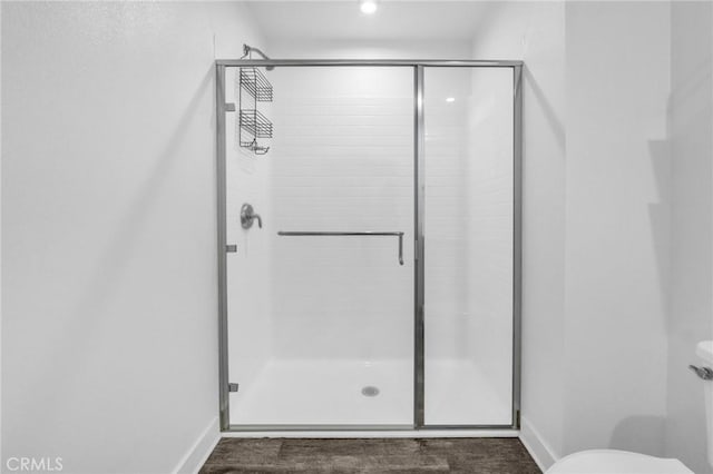 bathroom featuring hardwood / wood-style floors, toilet, and an enclosed shower