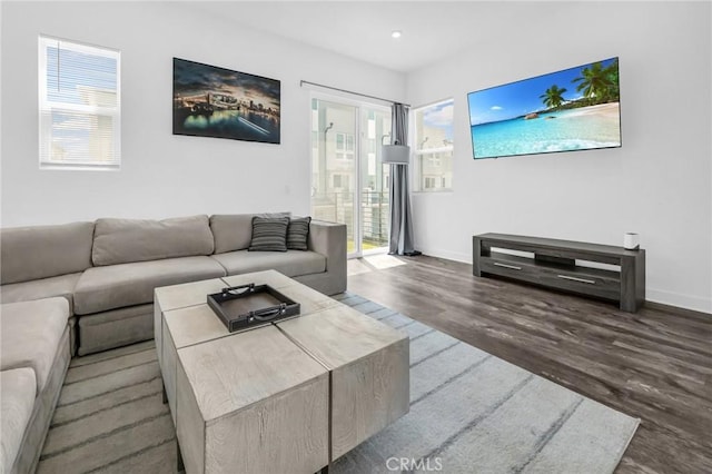 living room with dark hardwood / wood-style floors and a healthy amount of sunlight