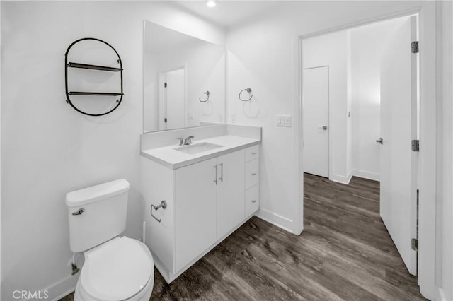 bathroom featuring toilet, vanity, and hardwood / wood-style flooring