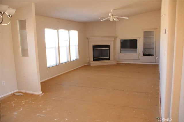 unfurnished living room with ceiling fan, a glass covered fireplace, and baseboards