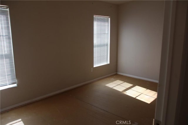 unfurnished room featuring baseboards