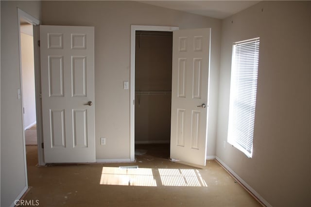 unfurnished bedroom with a closet, vaulted ceiling, and multiple windows