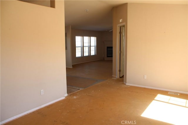 spare room featuring baseboards, a fireplace, and visible vents