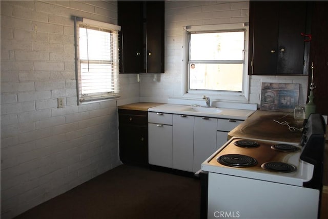 kitchen featuring a sink, light countertops, and white electric range