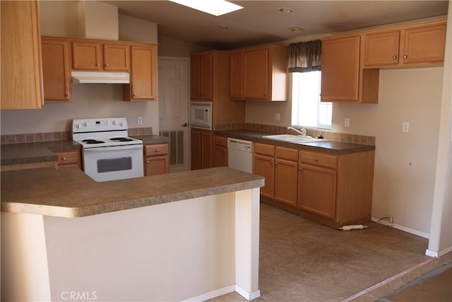 kitchen with white appliances, kitchen peninsula, vaulted ceiling, and sink