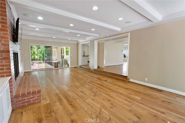 unfurnished living room with ornamental molding, beam ceiling, light wood-type flooring, and a brick fireplace