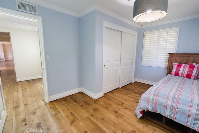 bedroom featuring light hardwood / wood-style floors, a closet, and crown molding