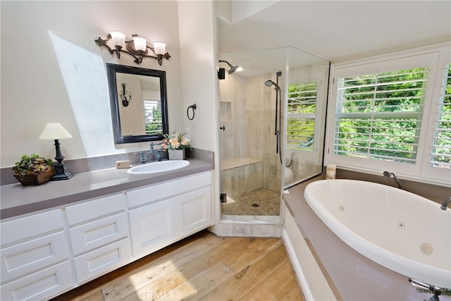 bathroom with vanity, hardwood / wood-style floors, shower with separate bathtub, and plenty of natural light