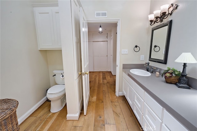 bathroom featuring toilet, hardwood / wood-style flooring, and vanity