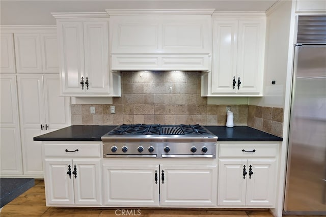 kitchen featuring appliances with stainless steel finishes, custom exhaust hood, white cabinetry, and wood-type flooring