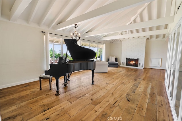 miscellaneous room with vaulted ceiling with beams, an inviting chandelier, wood-type flooring, and a large fireplace