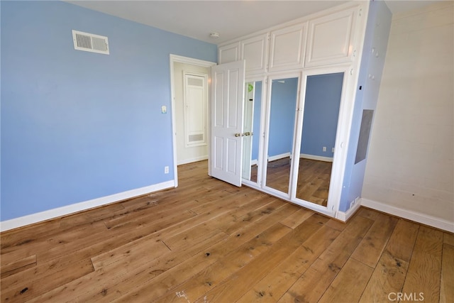 unfurnished bedroom featuring a closet and light hardwood / wood-style floors