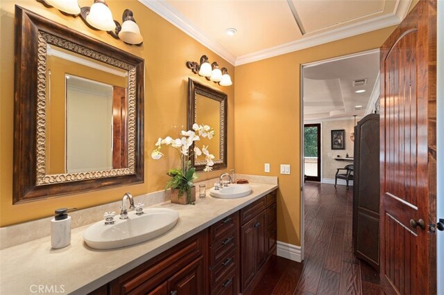 bathroom with vanity, hardwood / wood-style flooring, and crown molding