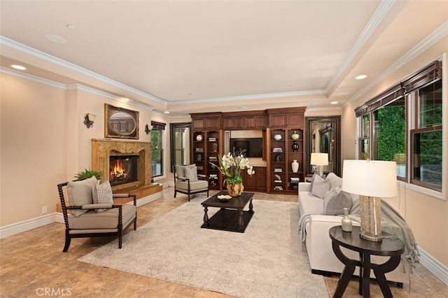 living room with a fireplace, ornamental molding, and a tray ceiling