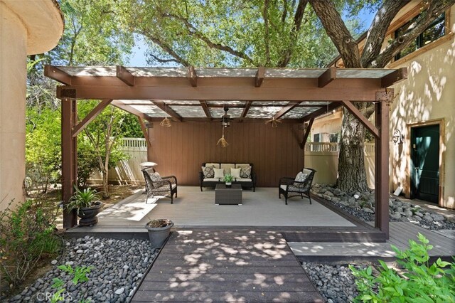 view of patio featuring an outdoor living space, a wooden deck, and a pergola