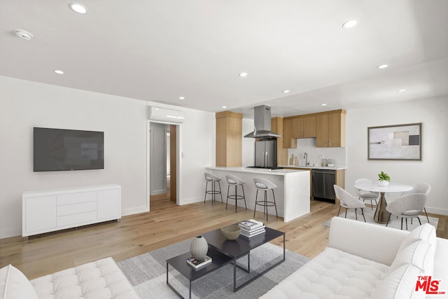 living room featuring a wall unit AC and light wood-type flooring