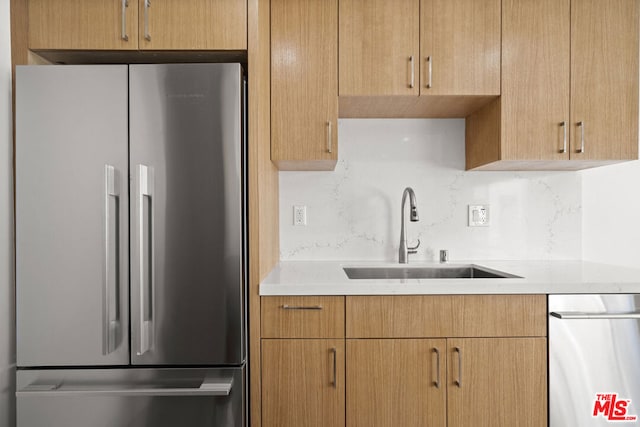 kitchen with tasteful backsplash, stainless steel appliances, and sink