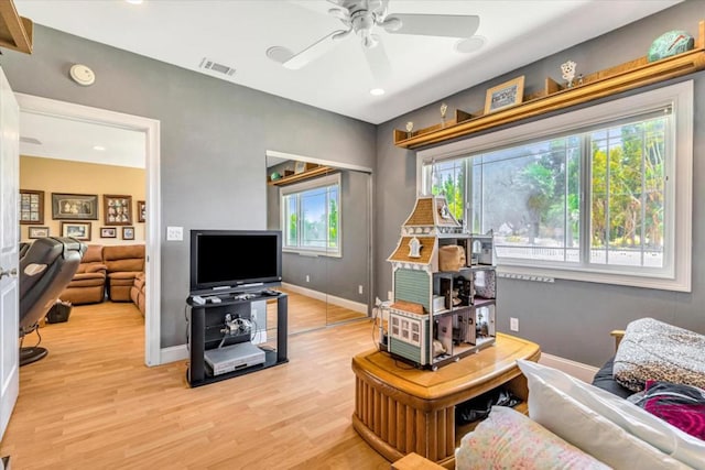 living room with light wood-type flooring and ceiling fan