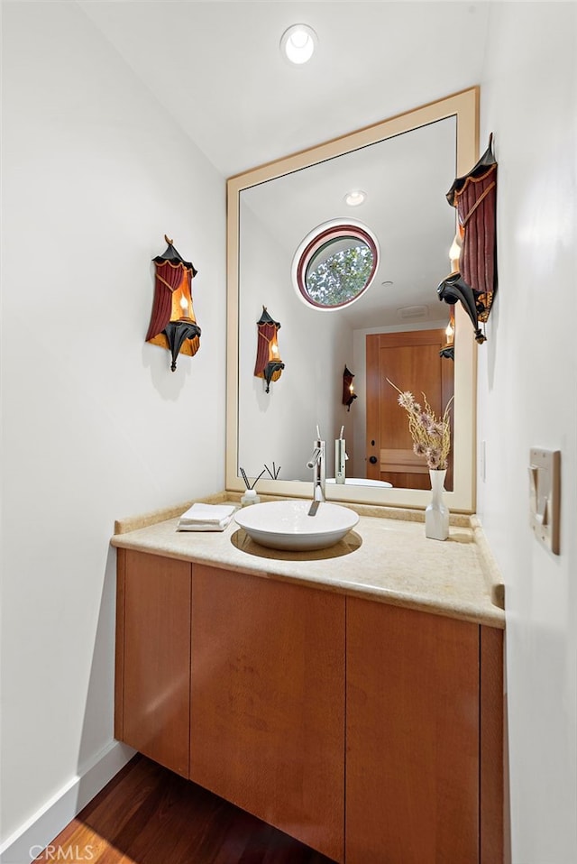 bathroom featuring recessed lighting, vanity, baseboards, and wood finished floors