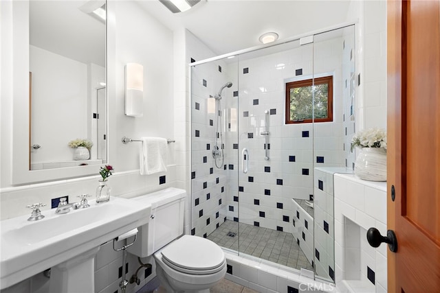 bathroom featuring a stall shower, visible vents, and toilet