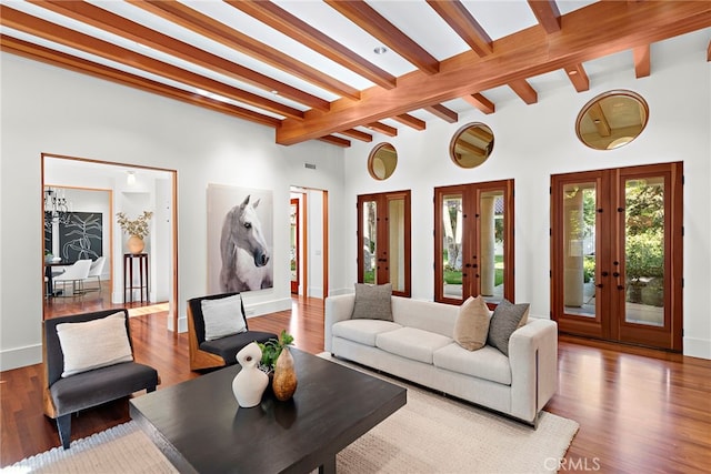 living area featuring french doors, beamed ceiling, and wood finished floors