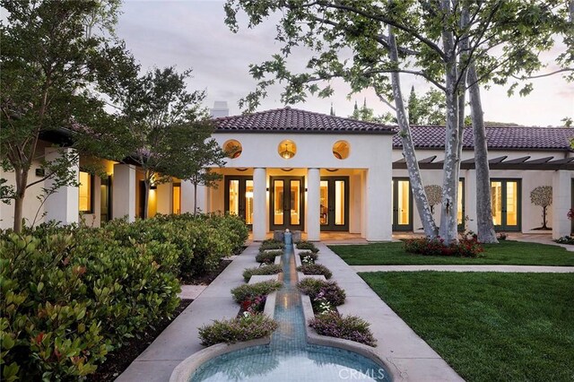 back of house with a yard and french doors