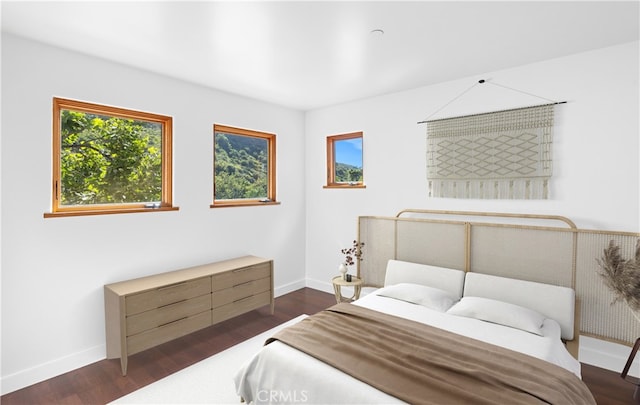 bedroom featuring dark wood-style floors and baseboards