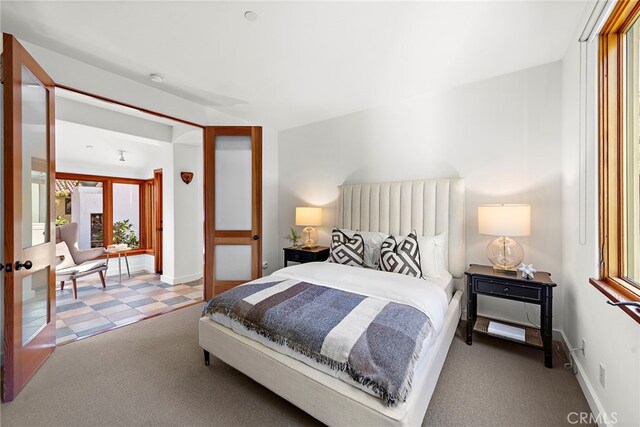 bedroom with french doors, carpet, and baseboards