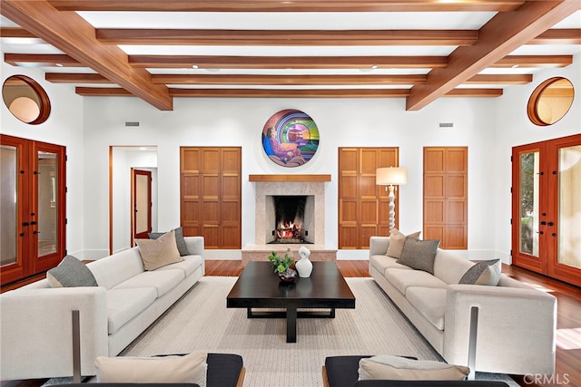 living area with french doors, beamed ceiling, and wood finished floors