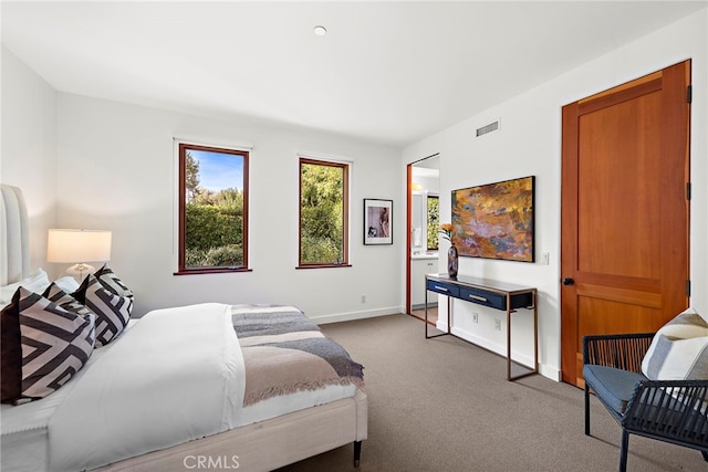 carpeted bedroom with visible vents and baseboards