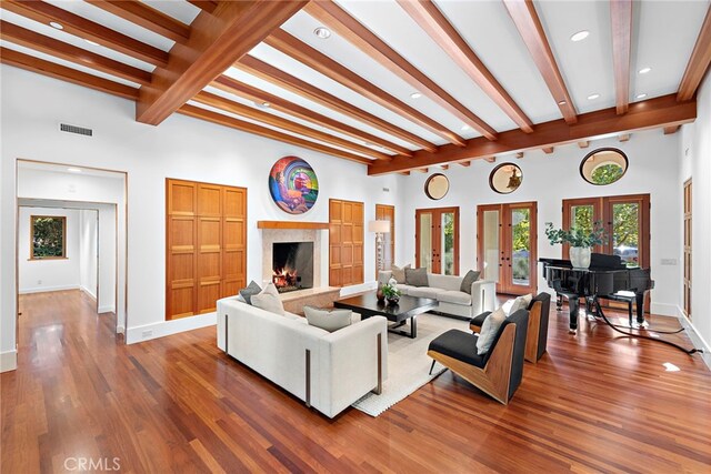 living room with french doors, a fireplace, wood finished floors, beamed ceiling, and baseboards