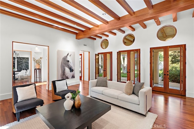 living room featuring french doors, lofted ceiling with beams, baseboards, and wood finished floors