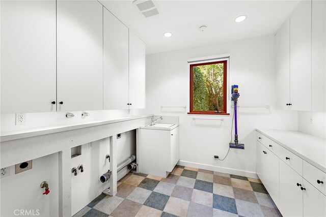 washroom with cabinet space, visible vents, light floors, a sink, and recessed lighting