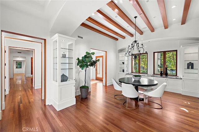 dining area featuring visible vents, baseboards, light wood-type flooring, beam ceiling, and an inviting chandelier