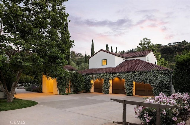 patio terrace at dusk with driveway and a garage